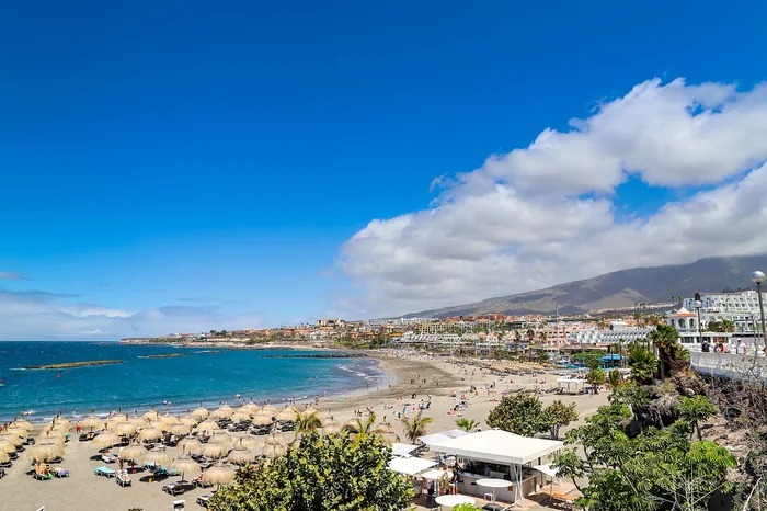 Beach, Atlantic water and waterfront buildings at Playa de Torviscas in Costa Adeje